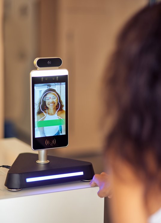 rear-view-of-female-office-worker-using-face-recog-2025-03-25-10-56-31-utc